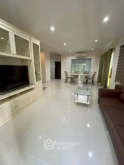 Spacious living room with modern furniture and dining area, perfect for family gatherings.