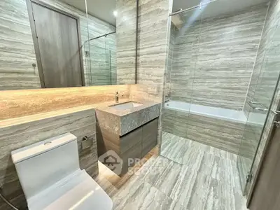 Luxurious modern bathroom with elegant marble finishes and glass shower enclosure.