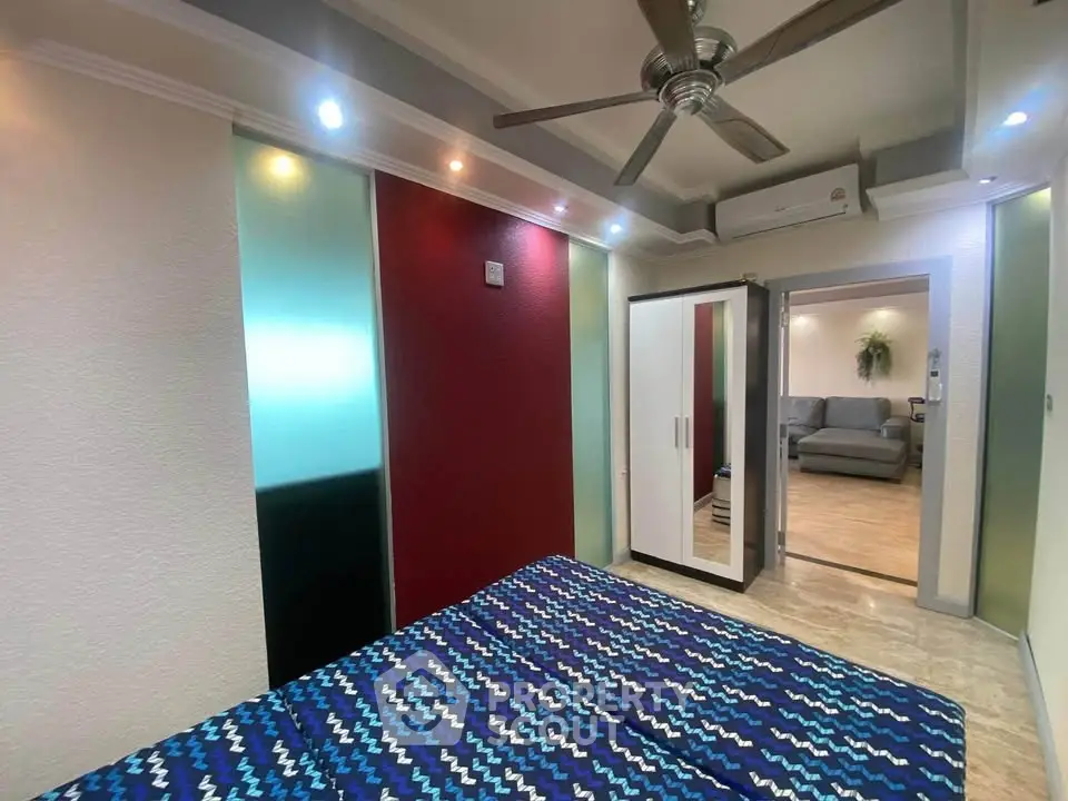 Stylish bedroom with modern decor and ceiling fan, adjacent to cozy living room.