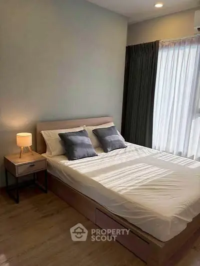 Cozy bedroom with modern decor and natural light, perfect for relaxation.