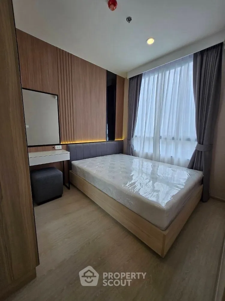 Modern bedroom with stylish wooden accents and large window for natural light.