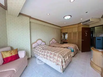 Spacious bedroom with twin beds and elegant decor in a modern apartment.