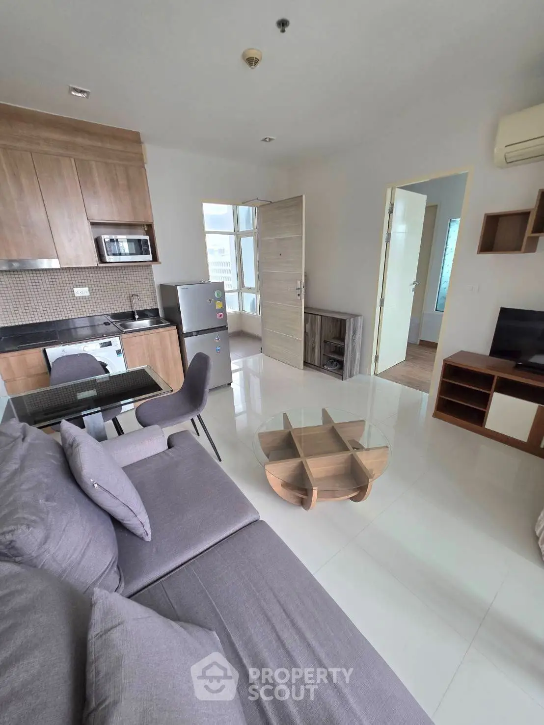 Modern open-plan living room with sleek kitchen and stylish furniture in a contemporary apartment.