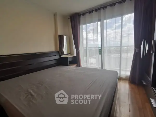 Spacious bedroom with large windows and balcony access offering a stunning view.