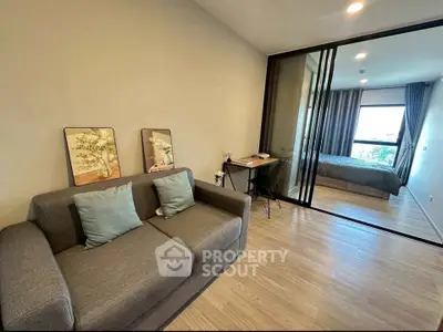 Modern living room with sliding glass doors leading to a cozy bedroom.