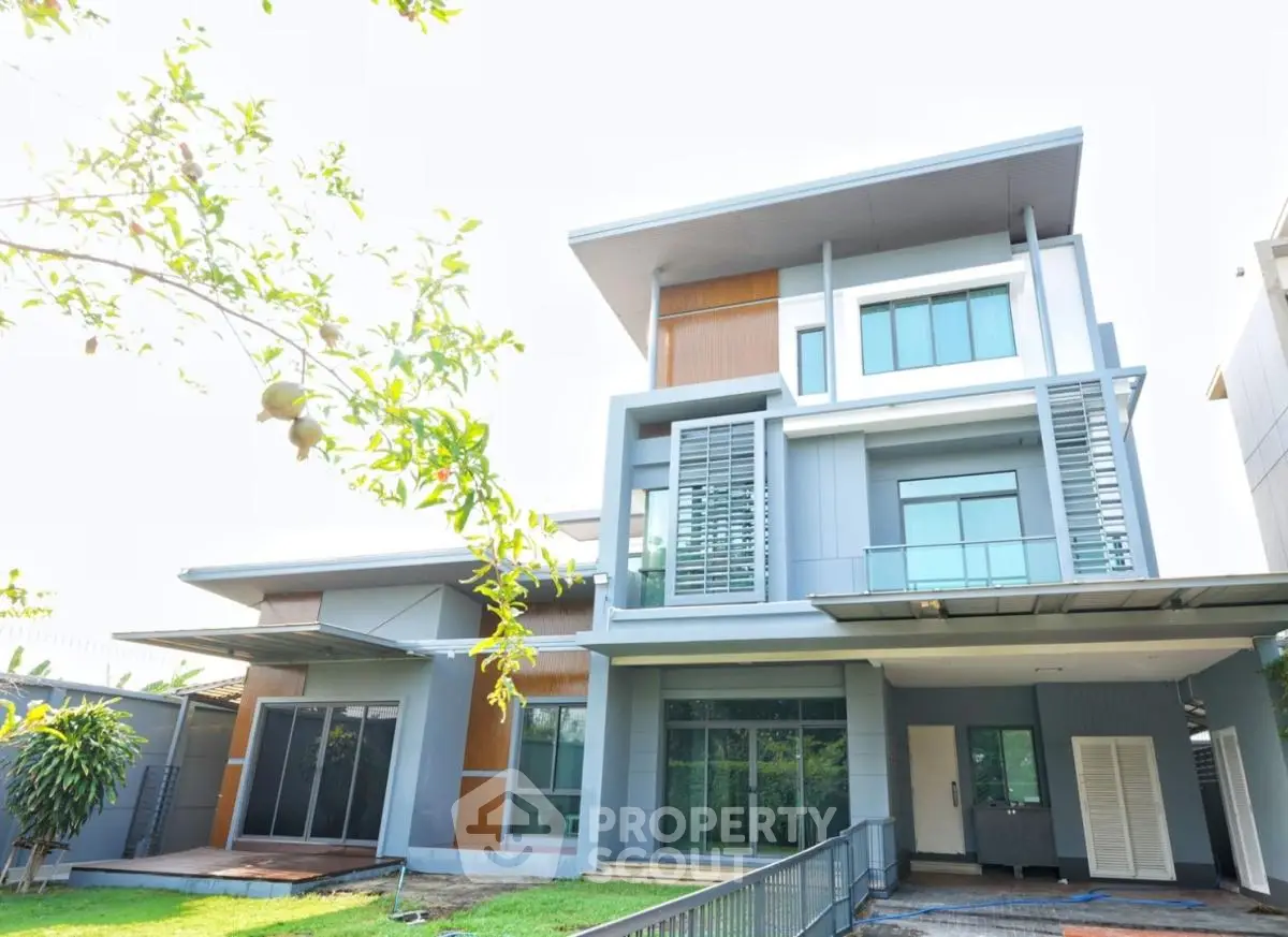 Modern multi-story house with sleek design and large windows in a suburban setting.