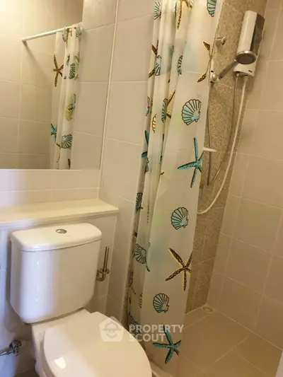 Modern bathroom with shower and decorative curtain in a stylish real estate property.