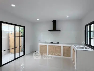 Modern kitchen with sleek design, featuring gas stove and ample natural light, perfect for culinary enthusiasts.