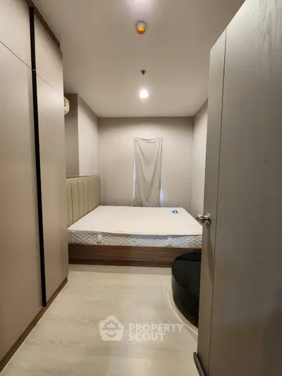 Cozy bedroom with modern minimalist design, featuring a large bed with a stylish headboard, sleek flooring, and soft lighting, perfect for urban living.