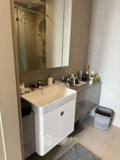 Modern bathroom with sleek sink and large mirror, showcasing contemporary design.