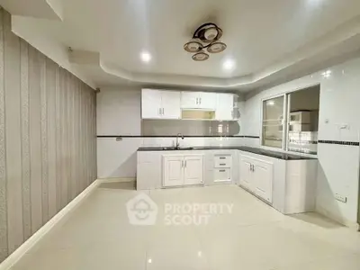 Spacious modern kitchen with sleek white cabinetry and elegant lighting