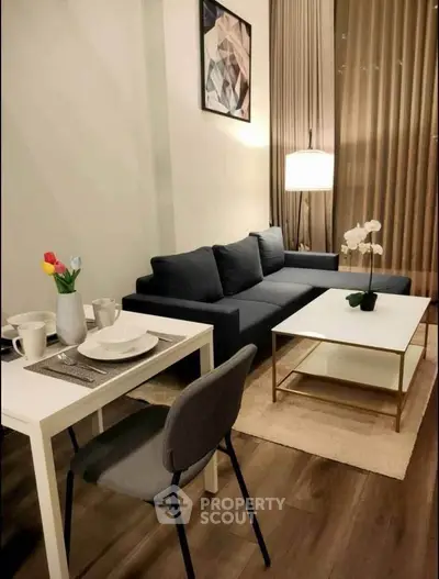 Modern living room with stylish decor, featuring a cozy sofa, elegant coffee table, and dining area.