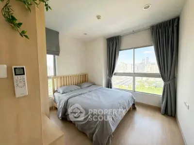 Bright bedroom with large window offering stunning city view, modern decor, and cozy ambiance.