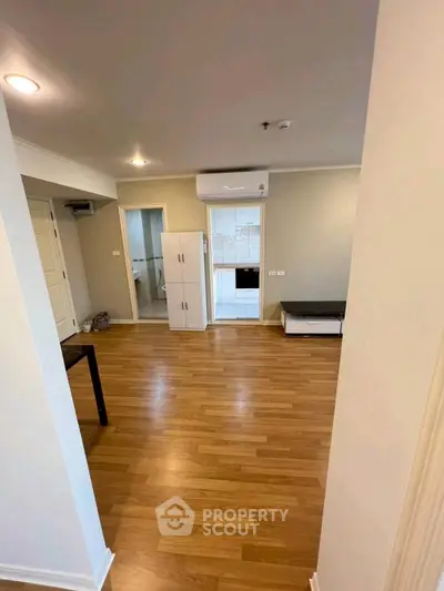 Spacious open-plan living area with wooden flooring and modern air conditioning.