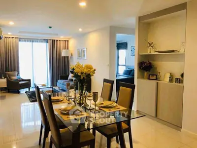 Elegant open-plan living and dining area with modern decor and natural light.