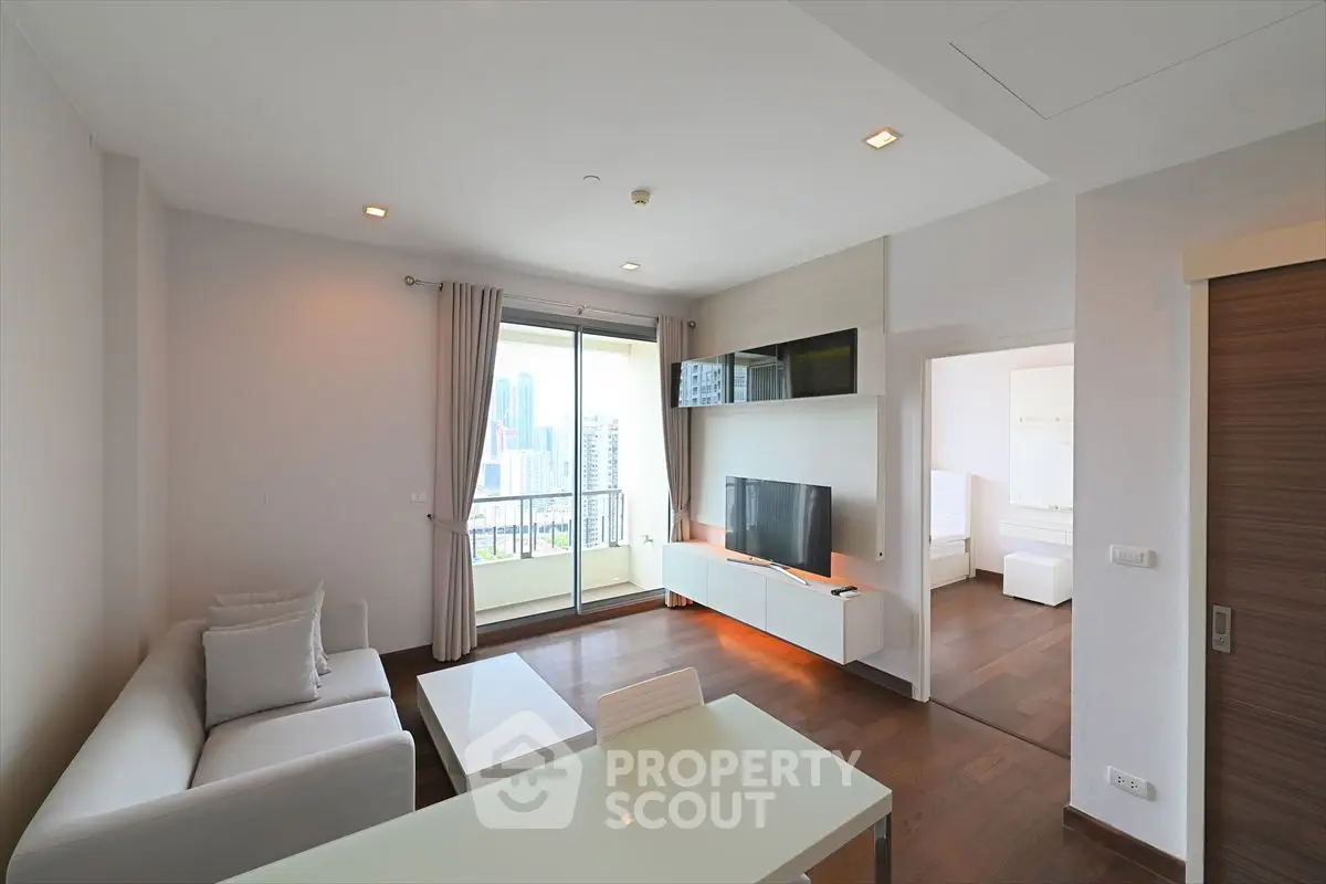 Modern living room with city view and sleek furniture in high-rise apartment.