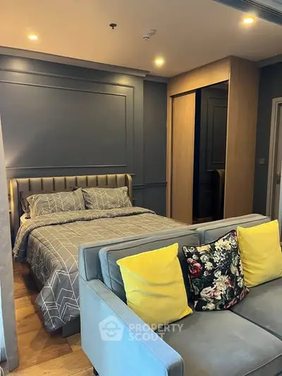 Modern bedroom with stylish decor and cozy seating area, perfect for relaxation and comfort.