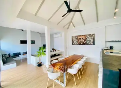 Spacious modern dining area with wooden table and stylish decor in open-plan living space.