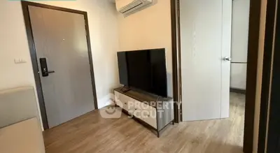 Modern living room with sleek TV setup and air conditioning in cozy apartment.