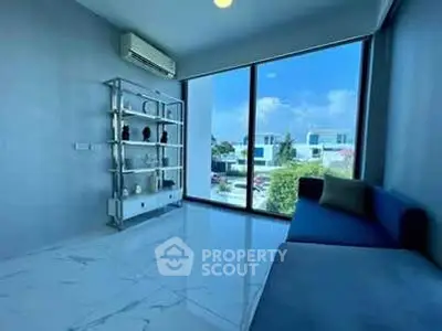 Modern living room with large window and sleek decor, offering a bright and airy atmosphere.