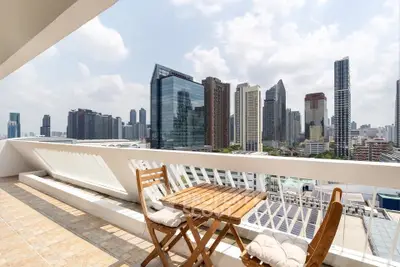 Stunning cityscape view from a spacious balcony with modern outdoor seating.