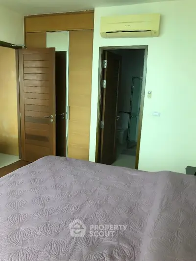 Cozy bedroom with air conditioning and ensuite bathroom in modern apartment