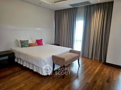 Spacious bedroom with elegant wooden flooring and stylish decor