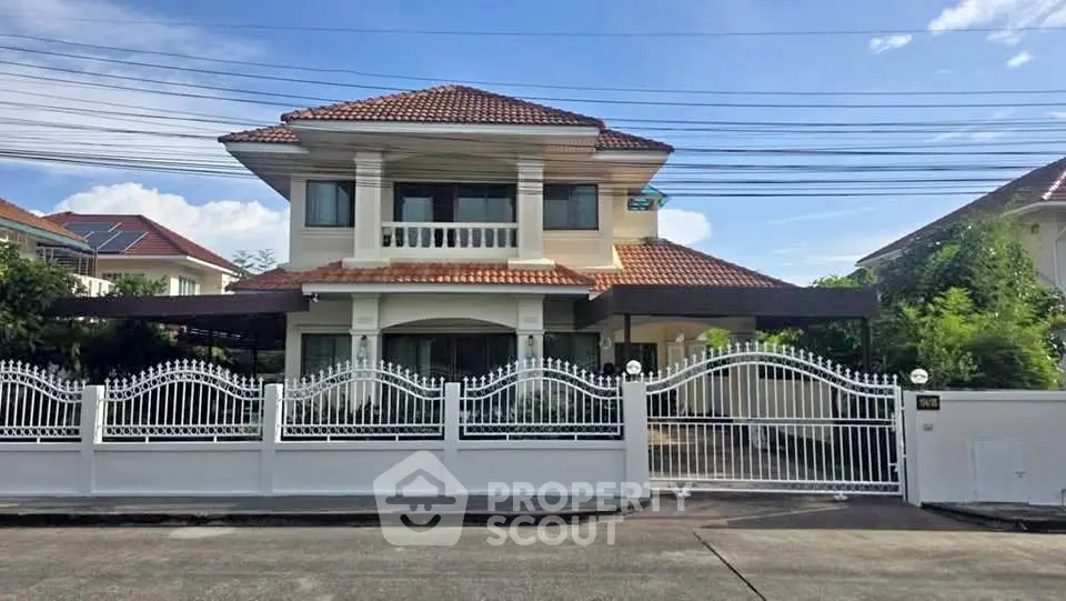 Charming two-story house with gated entrance and tiled roof in a serene neighborhood.