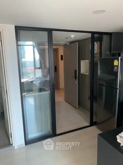 Modern kitchen with sleek glass sliding doors and stainless steel fridge