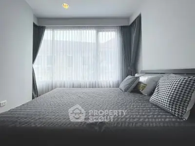 Spacious bedroom with large window and modern decor in a stylish home.