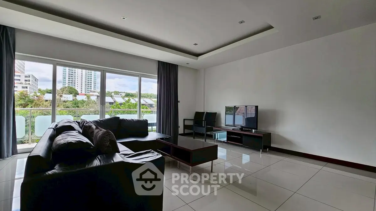 Spacious modern living room with large windows and sleek furniture.