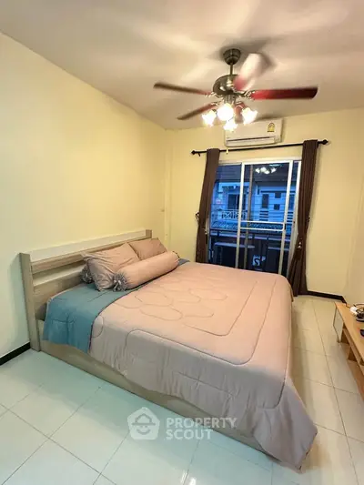 Cozy bedroom with modern ceiling fan and balcony view, perfect for relaxation and comfort.