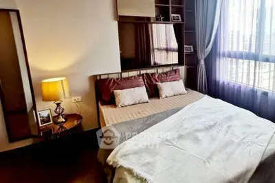 Cozy bedroom with large window and elegant decor, perfect for relaxation and comfort.