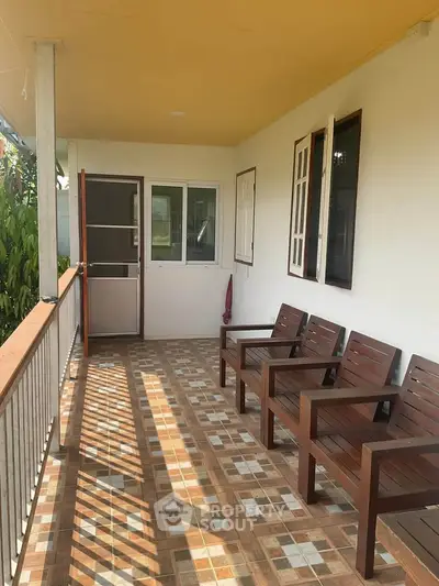 Charming balcony with wooden chairs and tiled floor, perfect for relaxation.