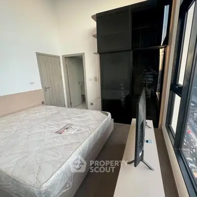 Modern bedroom with large window and sleek furnishings