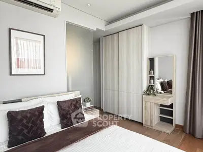 Modern bedroom with stylish decor and ample storage space in a contemporary apartment.