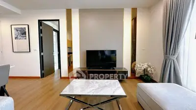 Modern living room with sleek furniture and TV, featuring elegant decor and natural light.