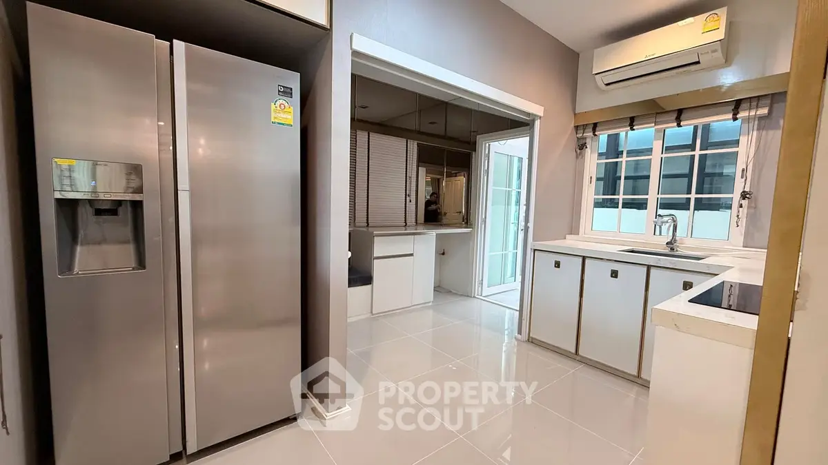 Modern kitchen with stainless steel fridge and sleek white cabinetry