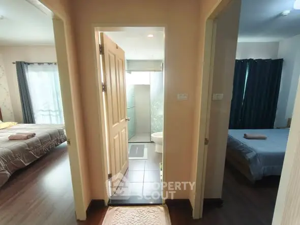 Spacious apartment hallway with access to two cozy bedrooms and a bathroom.