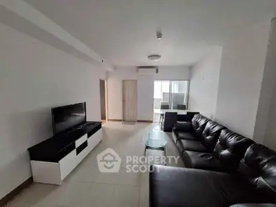 Spacious living room with modern leather sofa and flat-screen TV