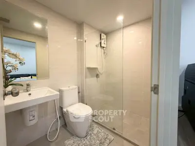 Modern bathroom with glass shower and sleek fixtures in a contemporary apartment.