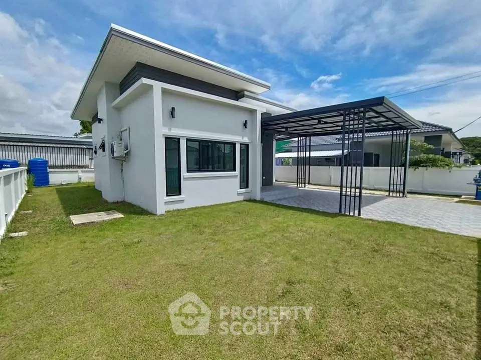 Modern single-story house with spacious lawn and covered carport
