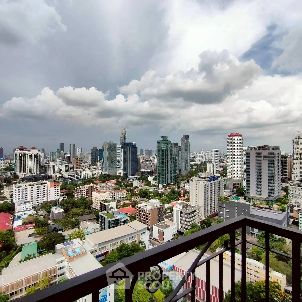 Stunning cityscape view from a high-rise balcony showcasing urban skyline and lush greenery.