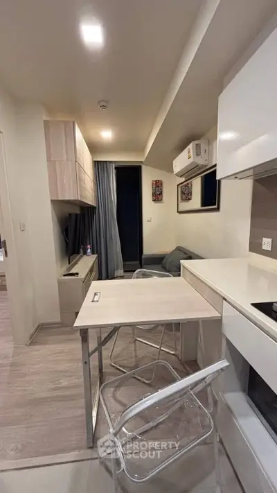 Modern compact living room with sleek furniture and open kitchen layout