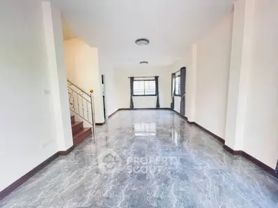 Spacious living room with elegant marble flooring and natural light, perfect for modern living.