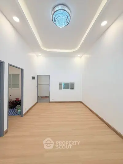 Spacious modern living room with elegant ceiling light and wooden flooring
