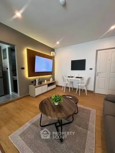 Modern living room with stylish decor and cozy dining area, featuring wooden flooring and ambient lighting.