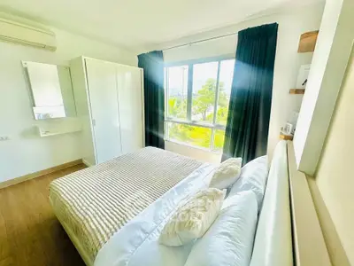 Bright and airy bedroom with large window and modern furnishings in a stylish apartment.