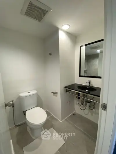 Modern minimalist bathroom with sleek fixtures and neutral tones.