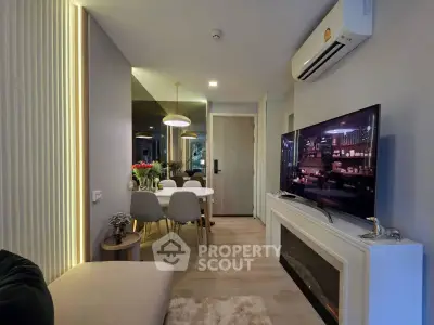 Modern living room with stylish decor, featuring a wall-mounted TV, dining area, and elegant lighting.